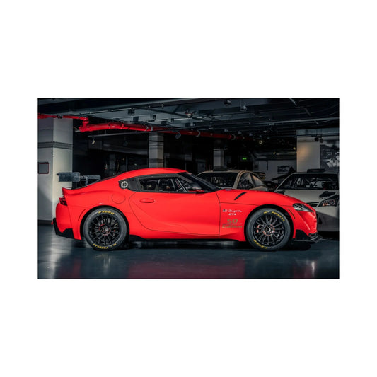 Red Toyota GR Supra GT4 race car with 50th edition decals in indoor garage