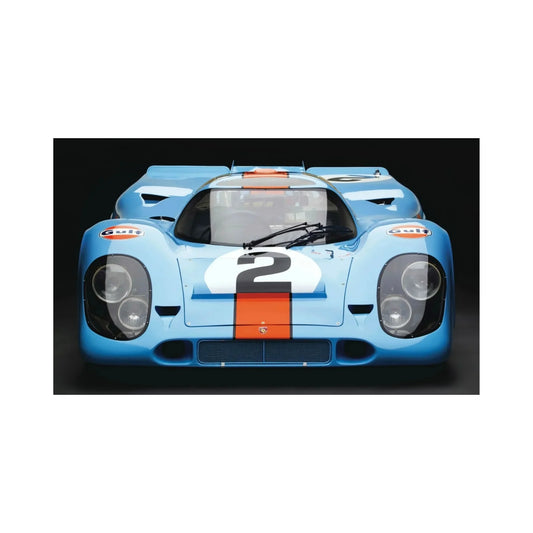 Front view of a blue vintage race car with orange stripe and number 2, Gulf logos on fenders