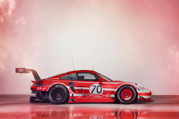Red and white Porsche 911 RSR race car with number 70 in a studio setting with soft pink lighting