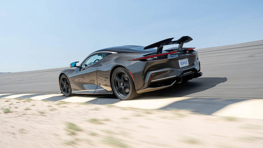 Black Pininfarina Battista electric hypercar on race track with rear spoiler