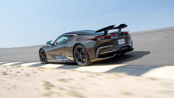Black Pininfarina Battista electric hypercar on race track with rear spoiler