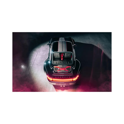 Overhead view of sleek black Porsche sports car with illuminated rear lights and red accents in dark setting