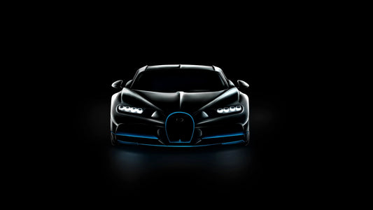 Front view of sleek black Bugatti Chiron Sport with illuminated headlights and blue accents on black background